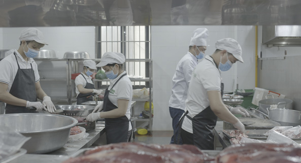 Nh&acirc;n vi&ecirc;n nh&agrave; bếp sơ chế thịt loại bỏ những phần dư thừa