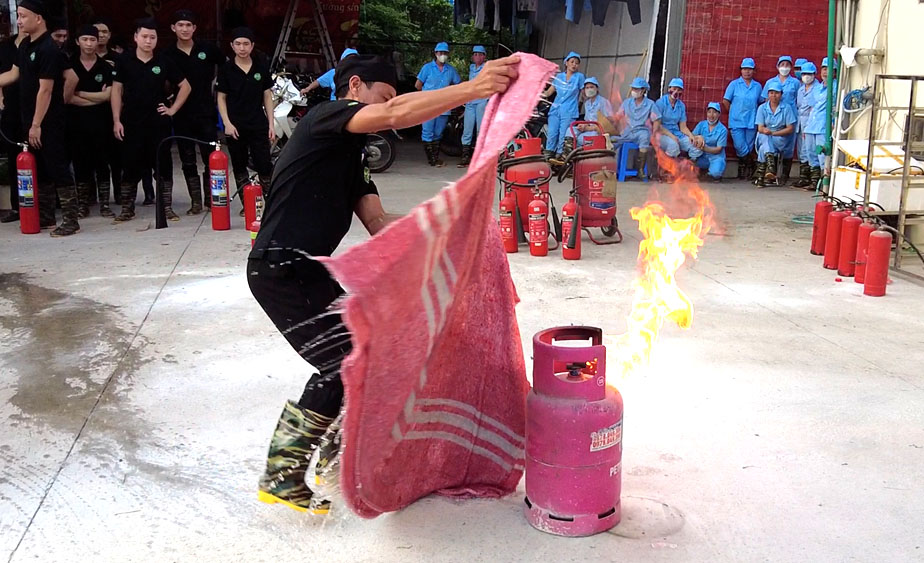 Nh&acirc;n vi&ecirc;n bảo vệ thực h&agrave;nh chữa ch&aacute;y b&igrave;nh ga